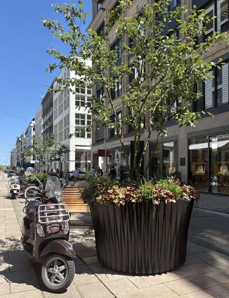 Gadebillede med planter og scooter i København