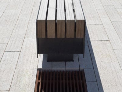 Moderne Sitzbank mit gusseisernem Rost darunter