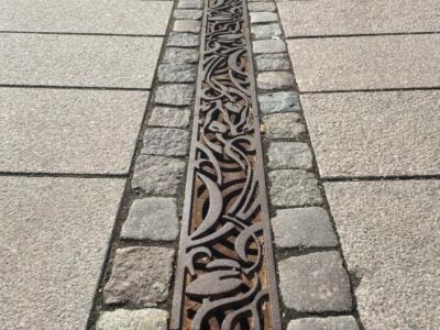 Dekorativ rende mellem fliser på fortov.