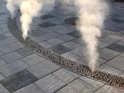 Damp stråler fra fortovet