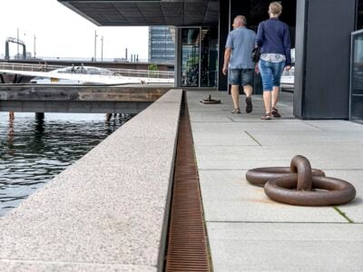Folk går langs vandkanten i byen