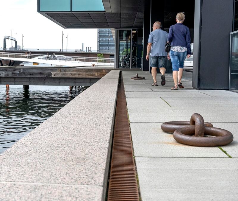 Folk går langs vandkanten i byen