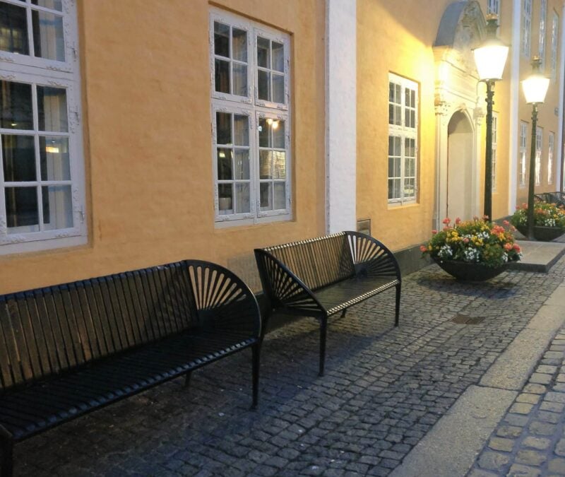 Bænke ved en bygning i aftenlys