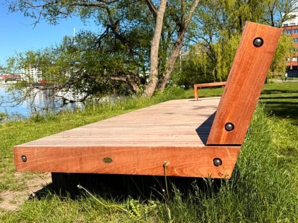 Bänk vid vattnet med gröna omgivningar.