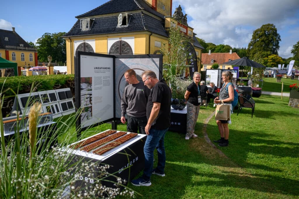 Menschen erkunden Ausstellungen in einem Park.