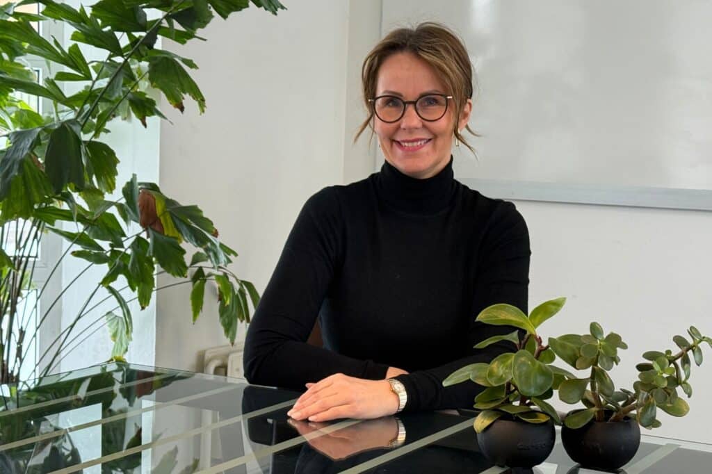 Kvinna sitter vid ett skrivbord med växter.