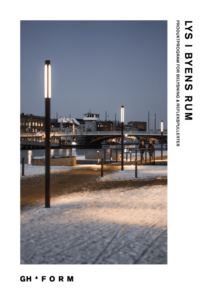 Moderne gadebelysning langs en snedækket havnepromenade i skumringen.