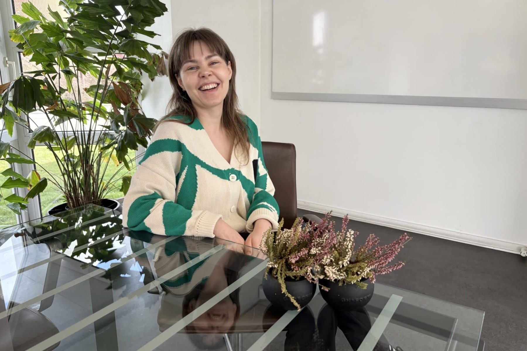 Kvinde smiler i et moderne kontor