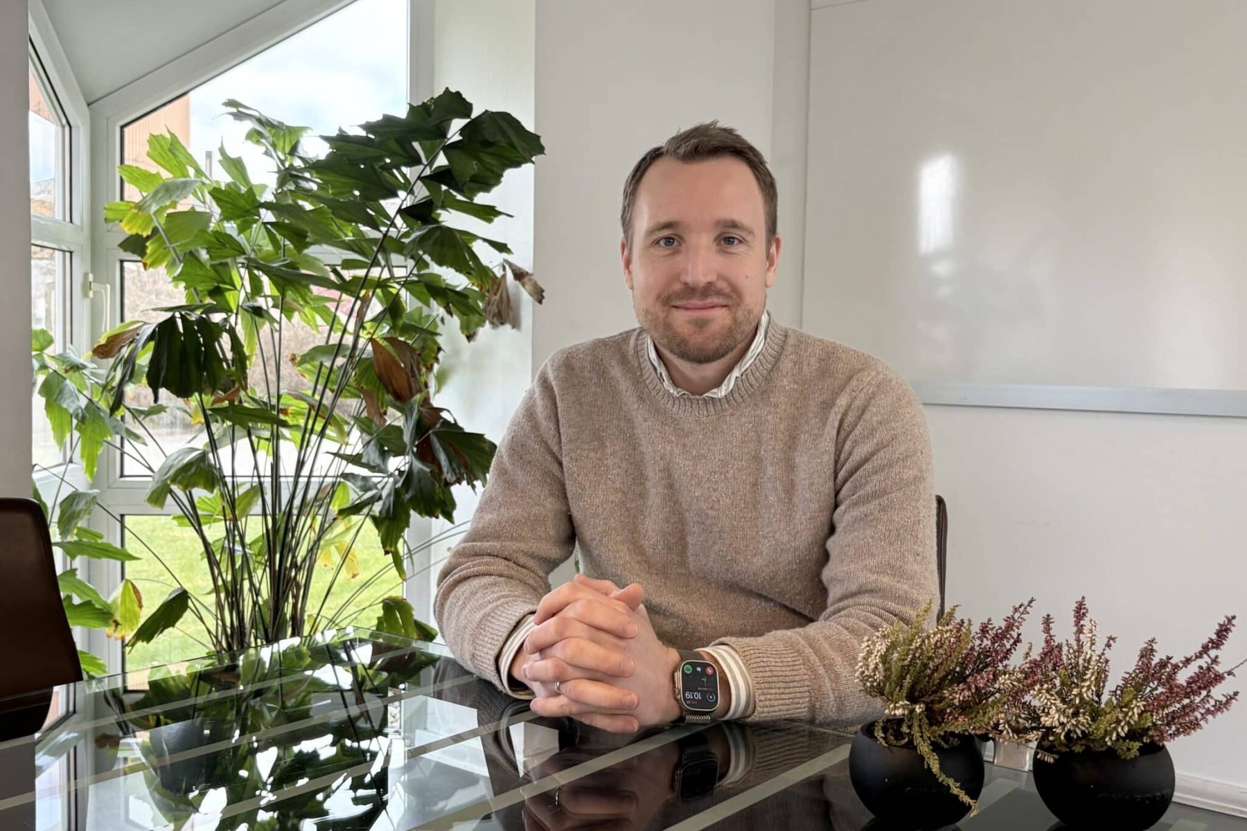 Mand sidder ved et bord med planter